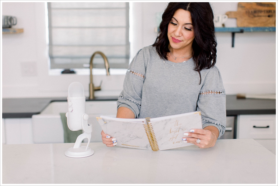 Brand Photography Woman reading a notebook in the kitchen with a microphone