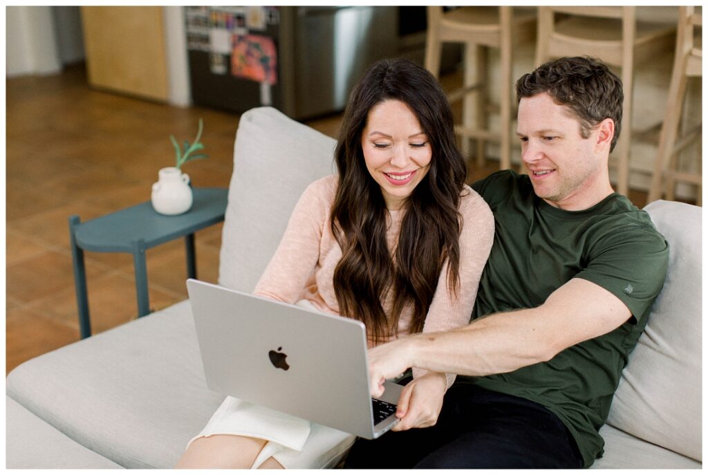 Arizona Brand Photographer couple looks at a laptop on the sofa 