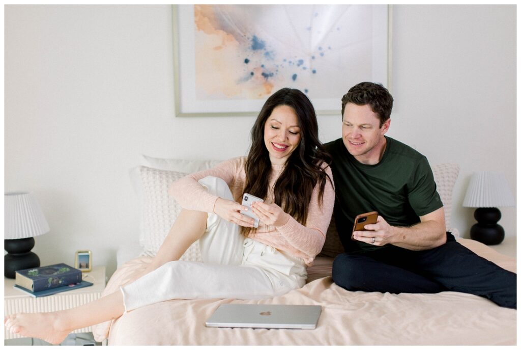 Arizona Brand Photographer couple sits in bed looking at their cell phones
