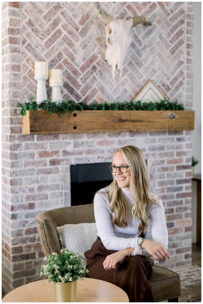Denise Karis Branding Photography woman sits in front of a brick fireplace