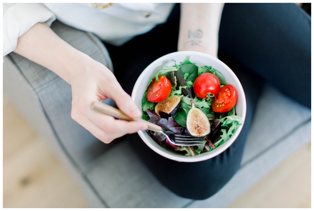 Hands holding a salad bowl with a colorful salad inside the bowl