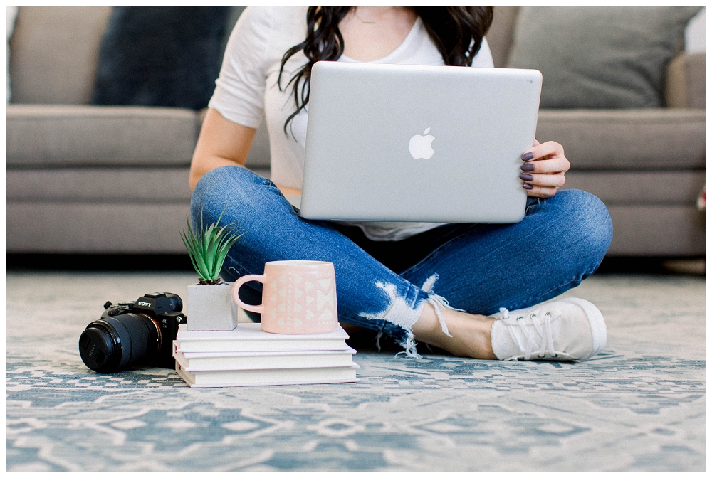 Branding portrait of a woman sitting on the floor working from home. A laptop is open in her lap