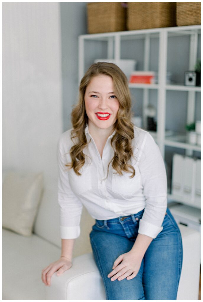 Branding Portrait of a woman seated on a sofa arm. 