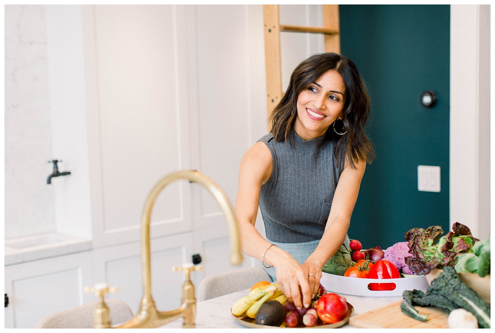 A woman handles produce in a kitchen. 