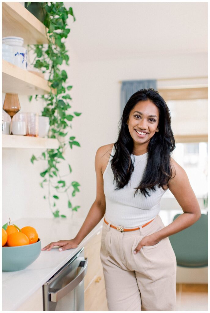 Branding Portrait a woman stands in a kitchen next to a bowl of oranges. 