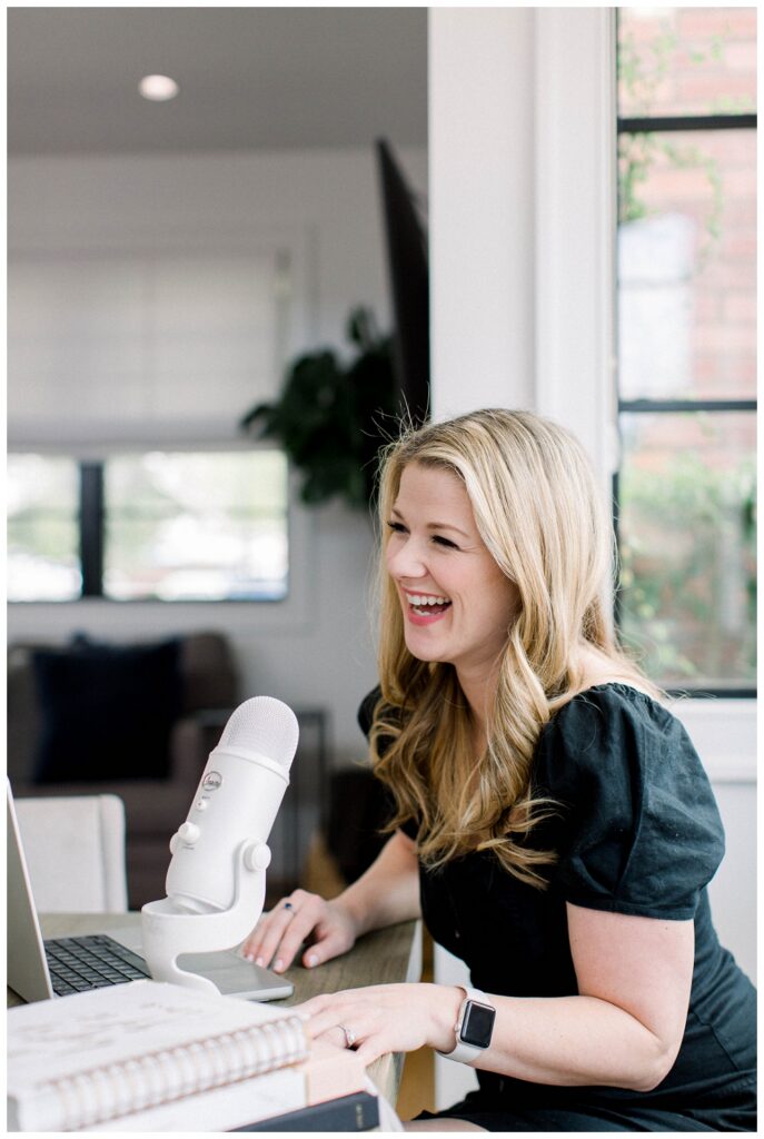 Branding Portrait a woman smiles while talking into a podcast mic. 