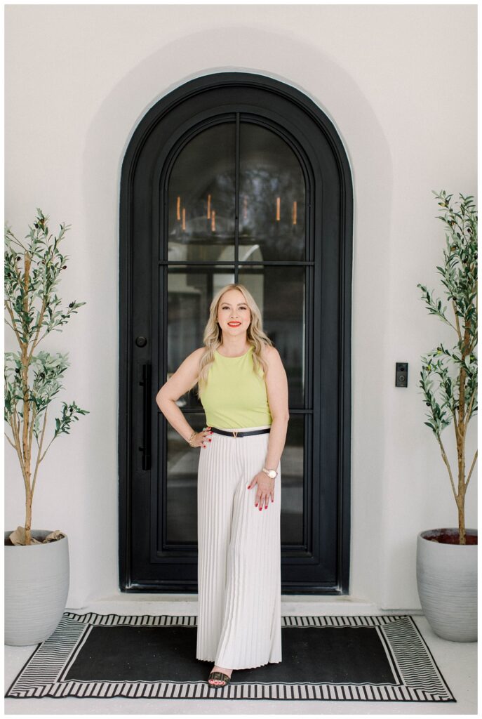 Branding Portrait a woman stands in front of a front door 