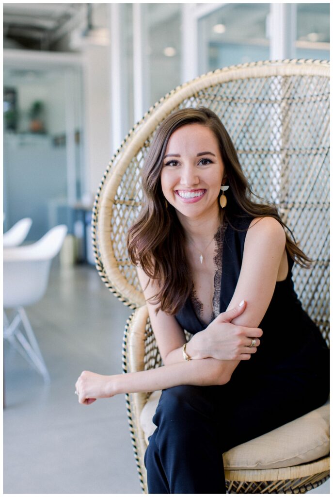 Branding Portrait a woman sits on a chair smiling at the camera. 