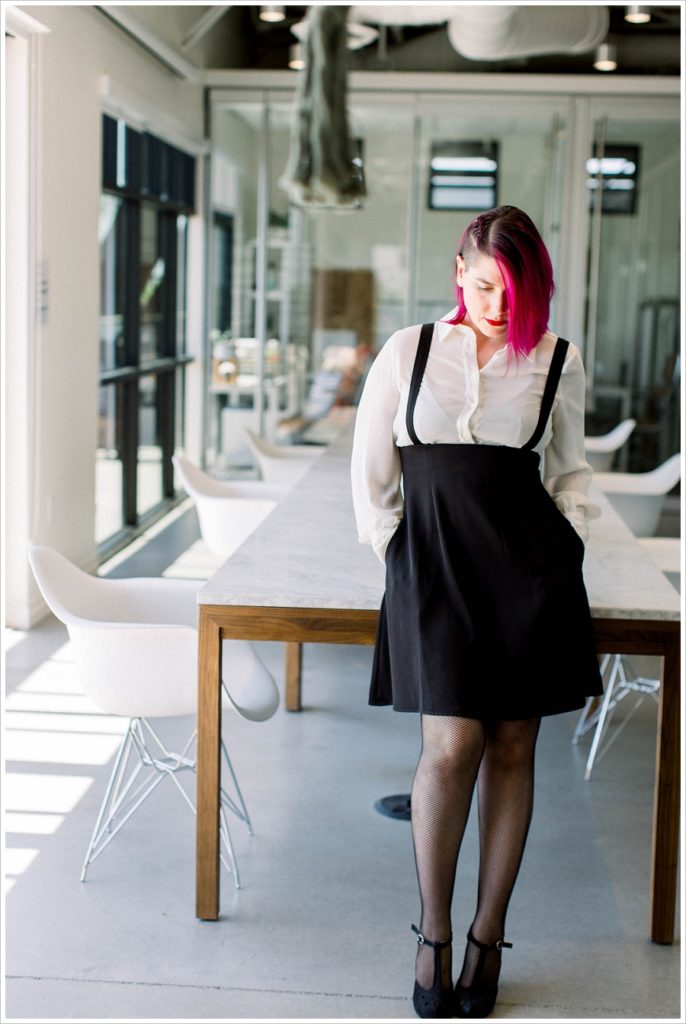 Woman in an office with pink hair